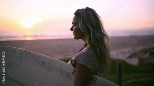Beach sunset, thinking and woman with a surfboard in nature for fitness, surfing or vacation hobby. Sunrise, freedom or lady surfer at the ocean for wellness, training or sea workout in water sports photo