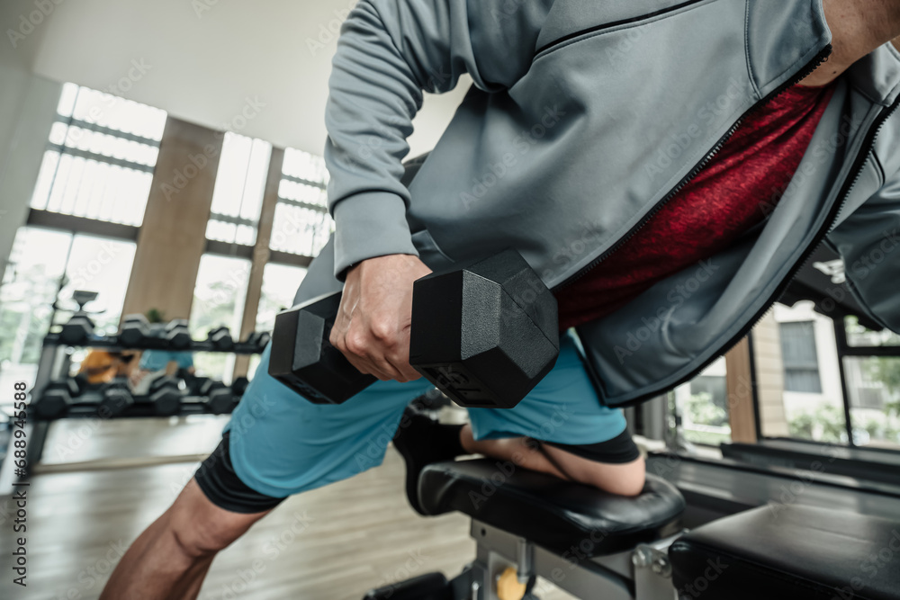 A man doing exercises triceps muscle with dumbbell in gym. Fitness, workout and traning concept. A man doing exercises triceps muscle with dumbbell in gym. Fitness, workout and traning concept.