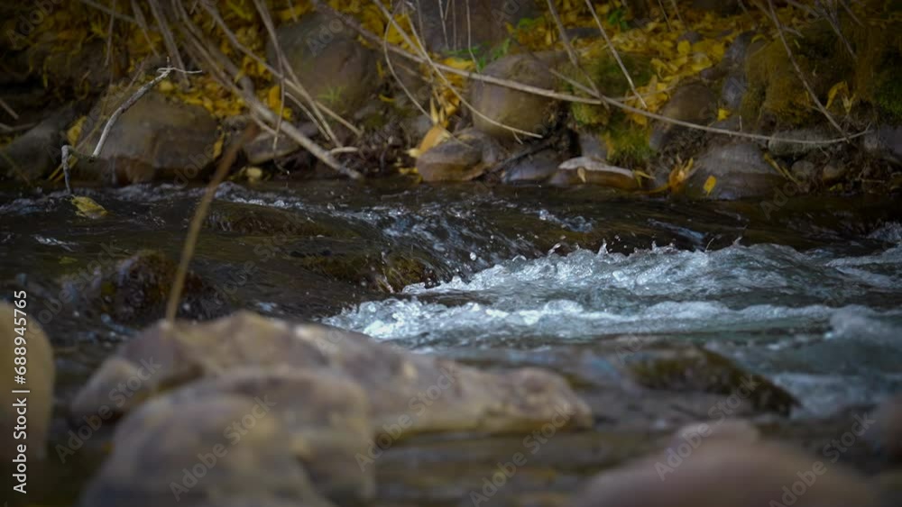 Fast Flowing Water Splashing Over Rocks In The River During Autumn - Slow Motion Fast Flowing Water Splashing Over Rocks In The River During Autumn - Slow Motion