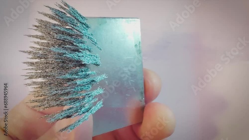 Iron filings moving in the magnetic field of a neodymium magnet, overhead shot. photo
