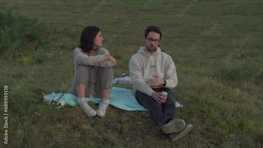 Evening Retreat: Couple Engages in Deep Conversation on Hillside Evening Retreat: Couple Engages in Deep Conversation on Hillside