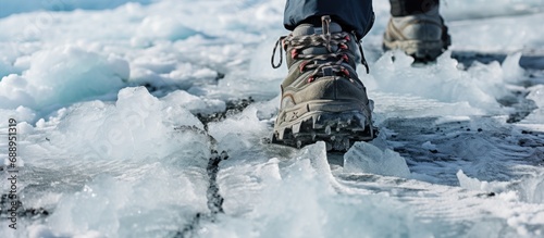 Walking on ice and snow in winter while trekking, with crampons and shoes. Close-up. photo