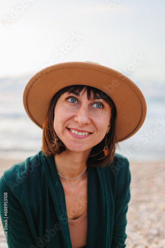 Beautiful natural beauty woman smiling and laughing, posing for the camera on the beach. Portrait of a young smiling girl in a hat,