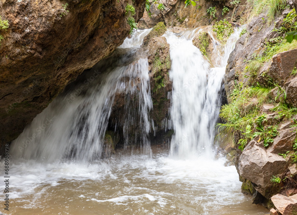 Naklejka premium Waterfall on a rocky river in the mountains