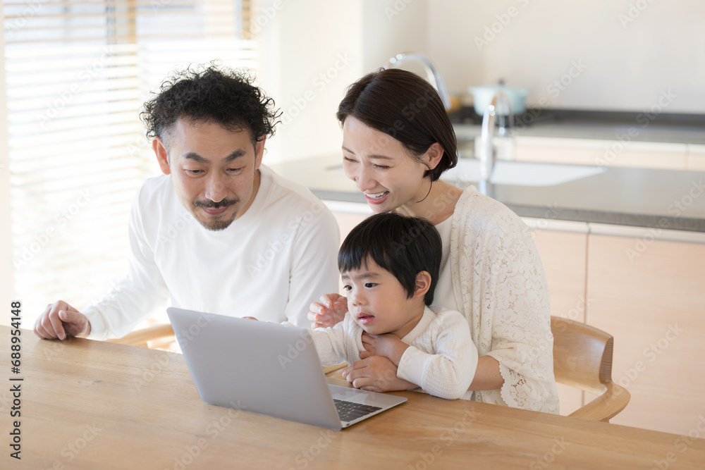 ダイニングでパソコンを使う家族　幼児教育などのイメージ