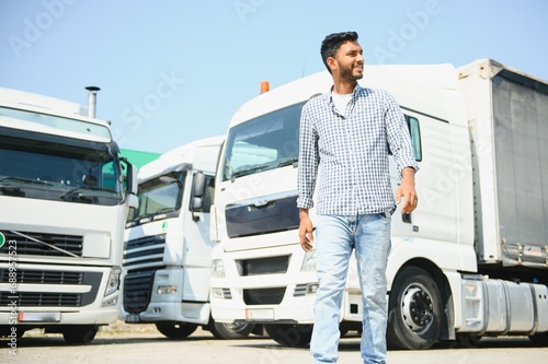 Young indian man standing by his truck. The concept of freight transportation.