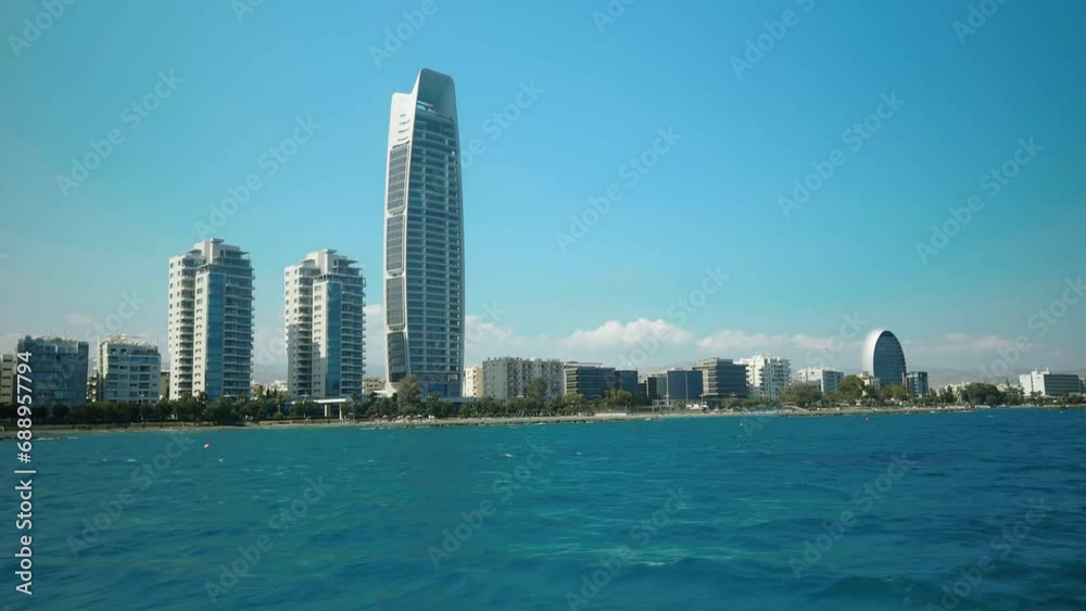 Panoramic view of Limassol's skyline from a moving boat. The bustling cityscape features towering skyscrapers along the shore, framed by the azure Mediterranean Sea and the iconic Limassol coastline. Panoramic view of Limassol's skyline from a moving boat. The bustling cityscape features towering skyscrapers along the shore, framed by the azure Mediterranean Sea and the iconic Limassol coastline.