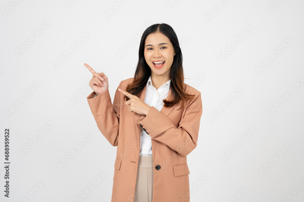 Young businesswoman, smiling while pointing finger left and showing thumbs up, recommending product Young businesswoman, smiling while pointing finger left and showing thumbs up, recommending product