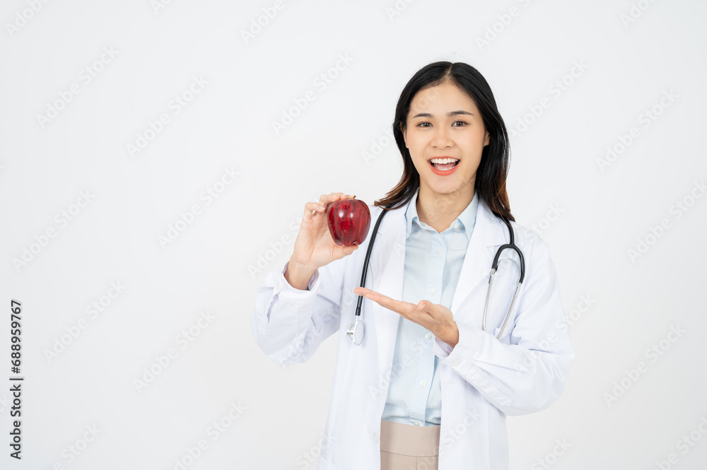 Female doctor with a white coat smiling and holding an apple. Female doctor with a white coat smiling and holding an apple.