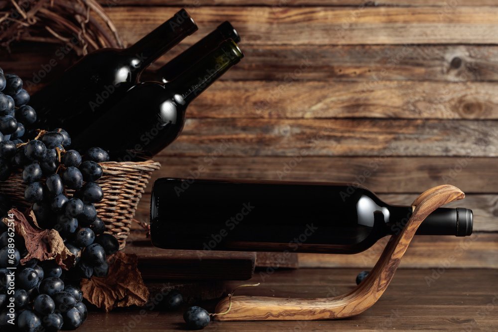Obraz premium Red wine and blue grapes on an old wooden table.