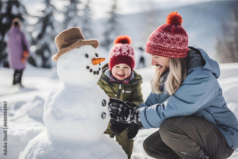A young father builds a snowman with his small child