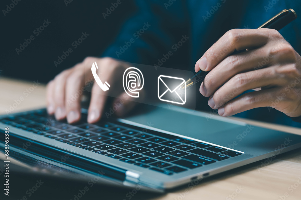 businessman using a laptop to contact customer support shows a contact icon ( address, phone, email, mobile, call ) contact us concept. help from mail websites  digital technology of business service - obrazy, fototapety, plakaty 