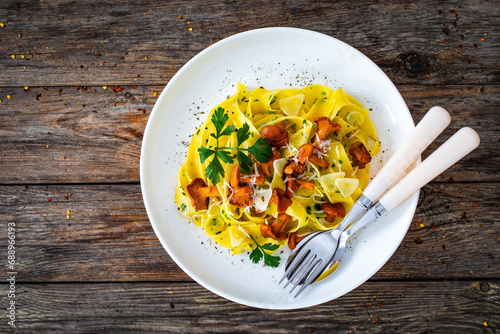 Pappardelle with chanterelle mushrooms on wooden table
