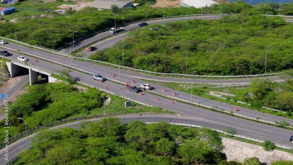 Wide angle aerial overview of workers replacing metal median barrier on highway Wide angle aerial overview of workers replacing metal median barrier on highway