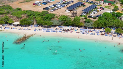 Drone trucking pan along Playa Porto Mari passing tourists swimming in turquoise water photo