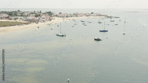 Catamaran And Sailboats Floating Near The Armona Island In Algarve, Portugal. - aerial tilt up shot photo