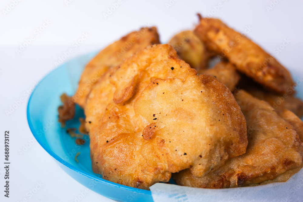 Flour fried tempeh on a blue plastic plate isolated on a white background Flour fried tempeh on a blue plastic plate isolated on a white background