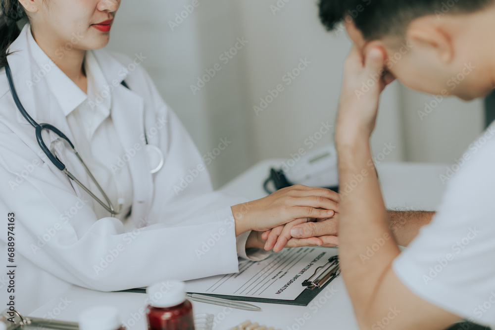 An Asian female doctor gives a pep talk to a male patient inside the hospital. An Asian female doctor gives a pep talk to a male patient inside the hospital.