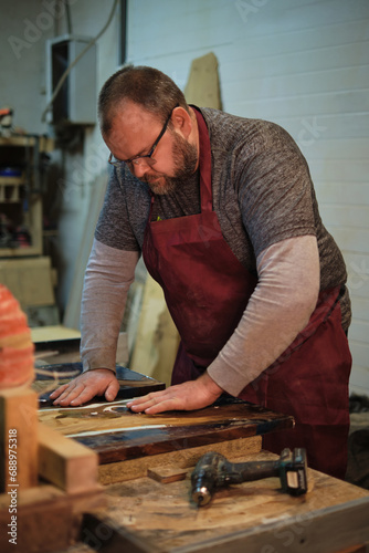 Hands guide wood through a cutter. Precision meets tradition in the modern maker's movement. photo