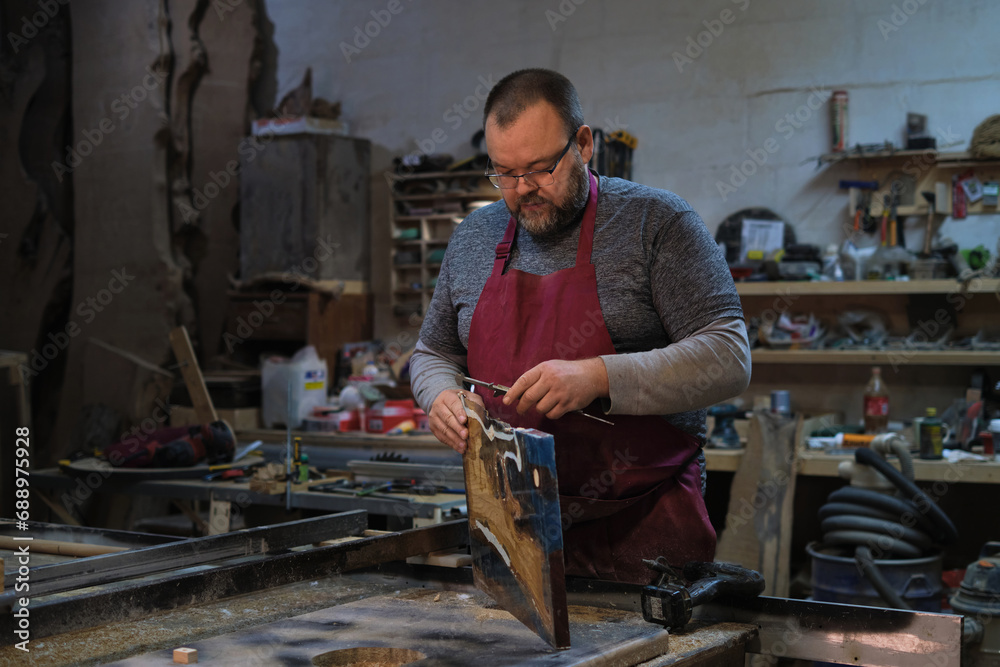 Man with planer on wood; meticulous and absorbed. Connects to the rising value of artisanal skills. Man with planer on wood; meticulous and absorbed. Connects to the rising value of artisanal skills.