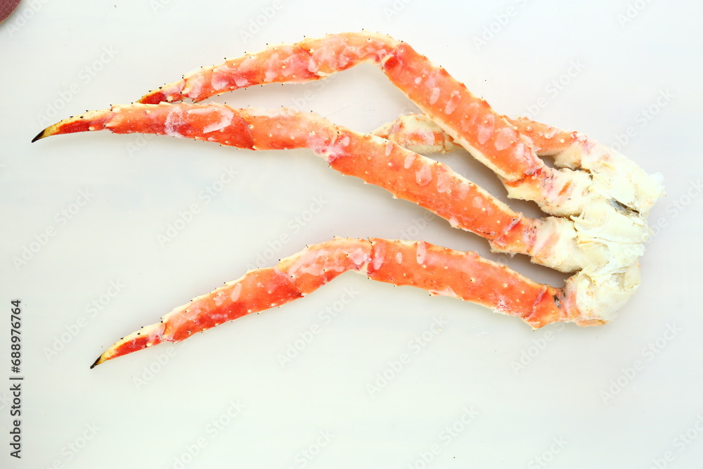 frosted Alaska king crab legs close up photo on white table background