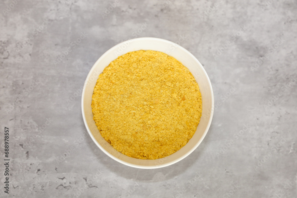 Fototapeta premium Top view of a bowl wit nutritional yeast flakes.