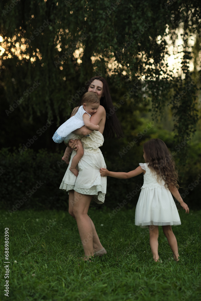 A spontaneous display of affection between a mother and her children, set against a backdrop of nature's bounty, this image captures the essence of familial intimacy and nurturing aspect of parenting