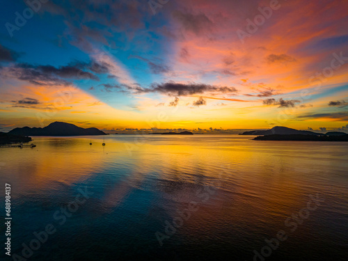 Amazing sunset or sunrise sky over sea landscape,Beautiful colorful light of nature with boats in the sea,Drone camera shot,Top down nature view seascape © panya99