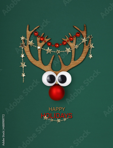 Funny Christmas deer and text Happy Holidays on green background photo
