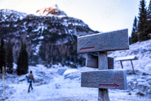 Hiking Copy Space Directions Wooden Board Covered with Morning Frost Copy Space in Winter Mountain Travel Destination With a Blurred Hiker in the Background © Fotopogledi