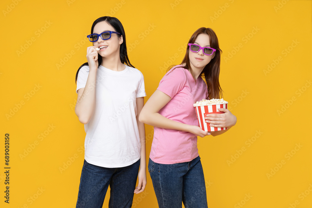 Two sisters in glasses and with popcorn in their hands