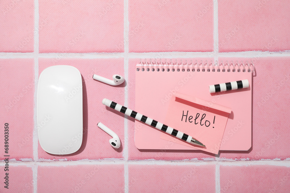 Notepad, note, pen and headphones on pink background, top view Notepad, note, pen and headphones on pink background, top view