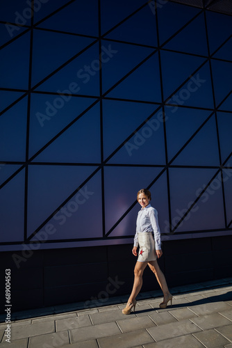 Beautiful fashionable woman near glass wall showcase
