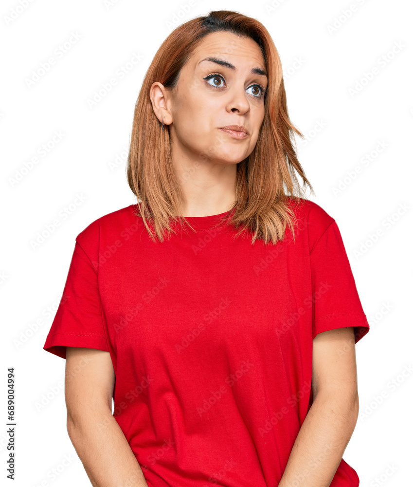 Hispanic young woman wearing casual red t shirt smiling looking to the side and staring away thinking. Hispanic young woman wearing casual red t shirt smiling looking to the side and staring away thinking.