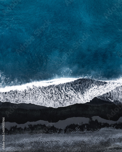 Fototapeta Naklejka Na Ścianę i Meble -  aeriel view of ocean waves on black sand beach