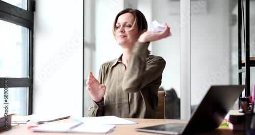 A business woman sitting in the office, coming a paper. The concept is useless work, a mistake in the calculations photo
