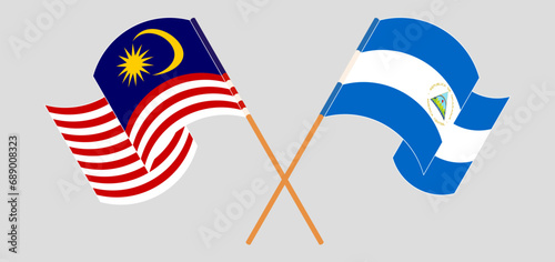 Crossed and waving flags of Malaysia and Nicaragua