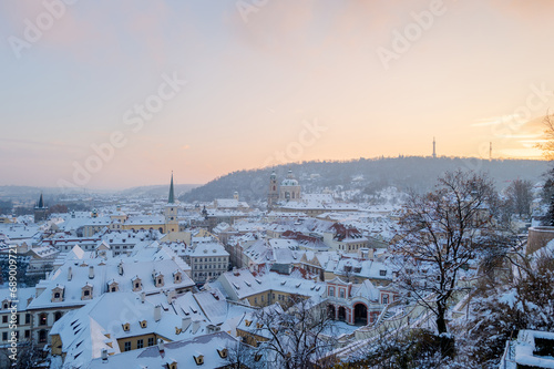 Rooftops of Lesser Town in Prague covered with snow at the sunset