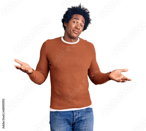 Handsome african american man with afro hair wearing casual clothes clueless and confused expression with arms and hands raised. doubt concept.