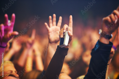 Hands, camera and a crowd of people at a music festival closeup with energy for freedom or celebration. Party, concert or event with an audience at a rock or musical performance or nightlife show photo