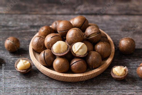 Close up macadamia nuts on wooden background.