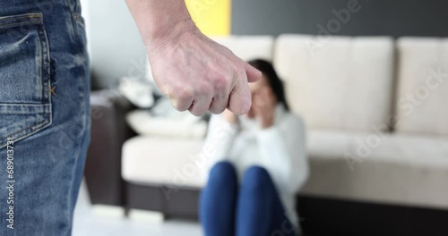 Man folding his fist in front of crying woman closeup 4k movie slow motion. Domestic violence concept photo