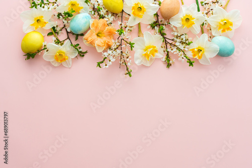Festive background with spring flowers and Easter eggs  white daffodils and cherry blossom branches on a pink pastel background