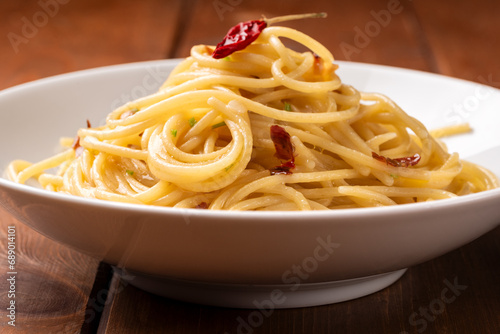 Piatto di tipici spaghetti conditi con aglio, olio e peperoncino, cibo italiano 