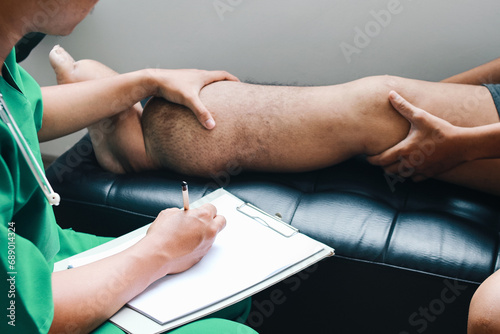 Doctor checking patient foot that suffering from filariasis or lymphatic filariasis and making notes in clipboard