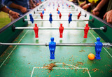 Playing, foosball and people outdoor with table, game or closeup on competition with ping pong ball. Soccer, board and small plastic football players or toys for social, event or sport at pub for fun