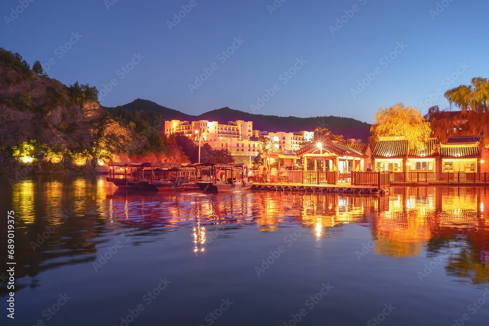 View of the beautiful Yangui Pier in the ancient Chinese village of Gubei Water Town with reflections in water and tourist boats moored in the harbour, Gubeikou, Miyun, Simatai, Beijing, China