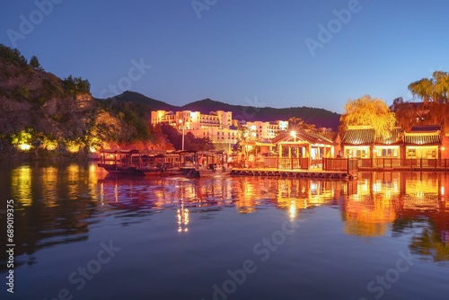 View of the beautiful Yangui Pier in the ancient Chinese village of Gubei Water Town with reflections in water and tourist boats moored in the harbour, Gubeikou, Miyun, Simatai, Beijing, China photo