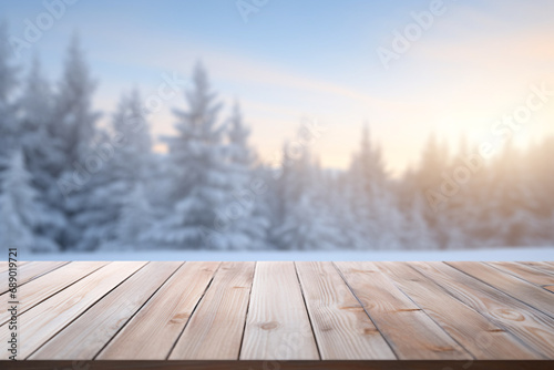 A wooden table for product display with a blurry winter background