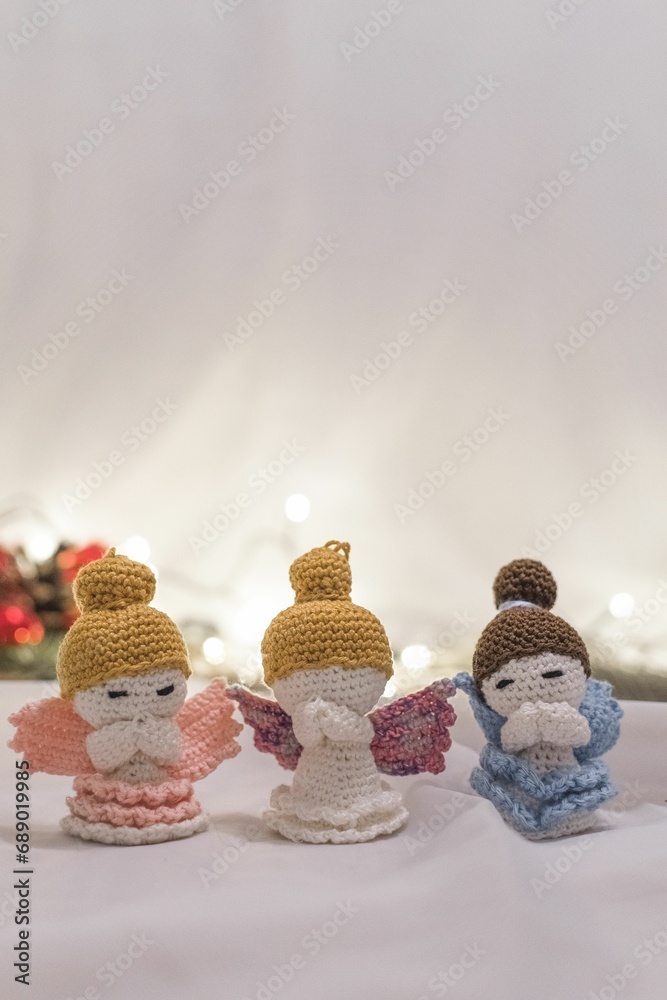 four crocheted dolls are arranged on a table next to garlands